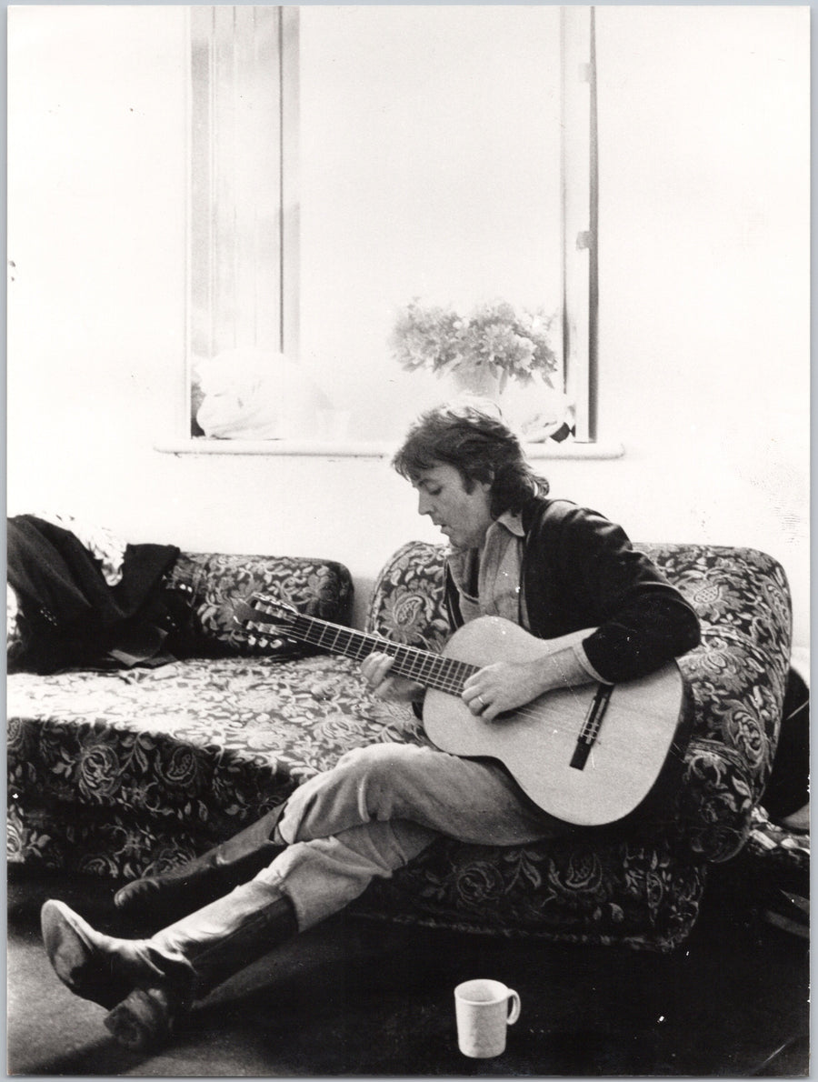 Paul McCartney Playing Acoustic Guitar on a Sofa