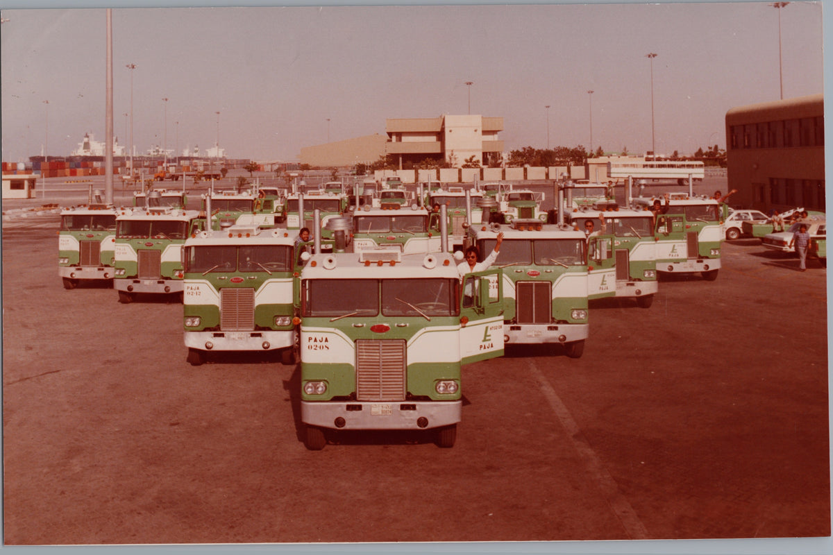 Green and White Truck Fleet at a Depot — front